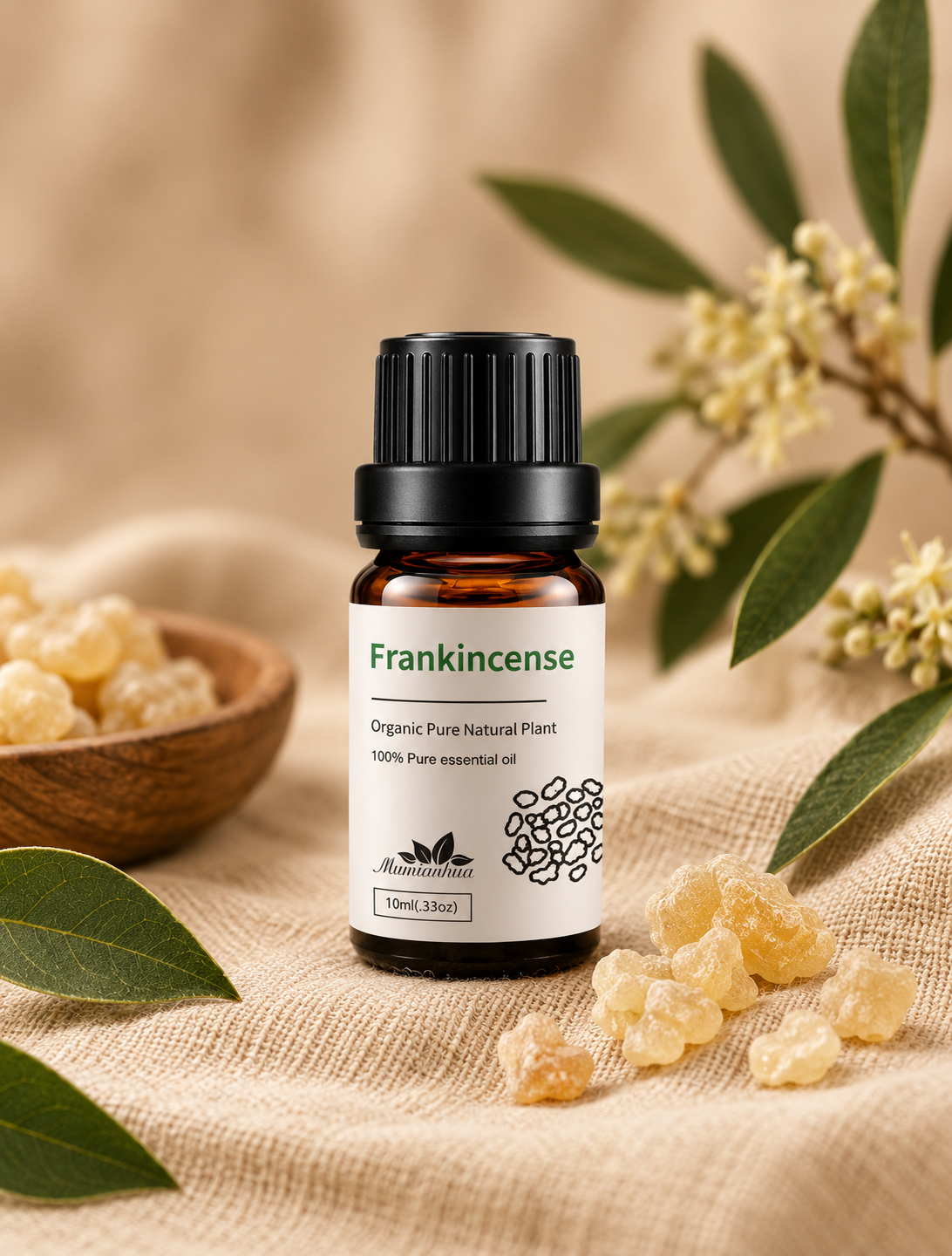 Amber Frankincense essential oil bottle with white botanical label beside golden frankincense resin pieces and a small wooden bowl on warm beige linen