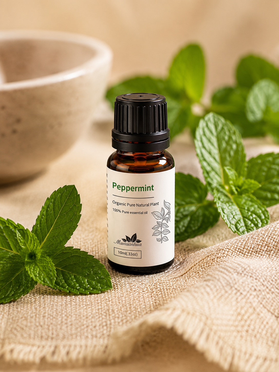 Amber Wellthious essential oil bottle with fresh peppermint leaves on beige linen